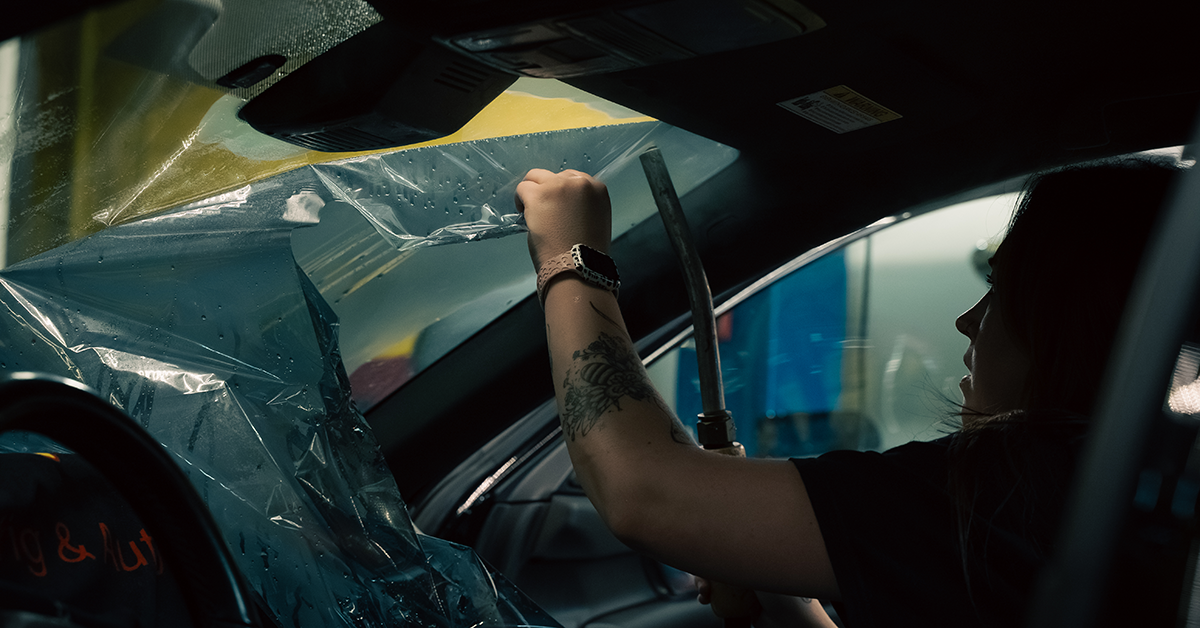 Technician applying car window tint