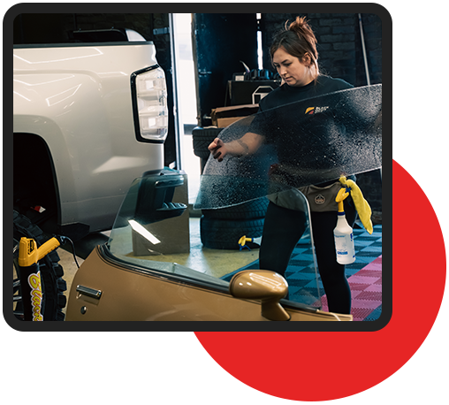 Technician applying car window tint