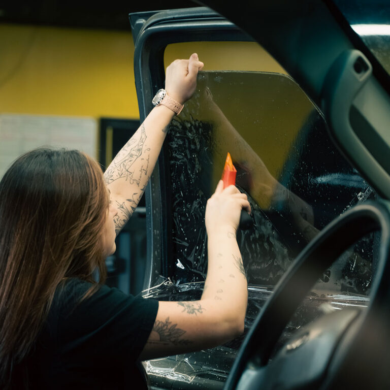 Technicians applying car window tint