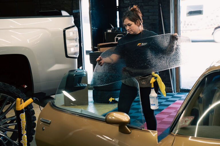 Technician applying car window tint